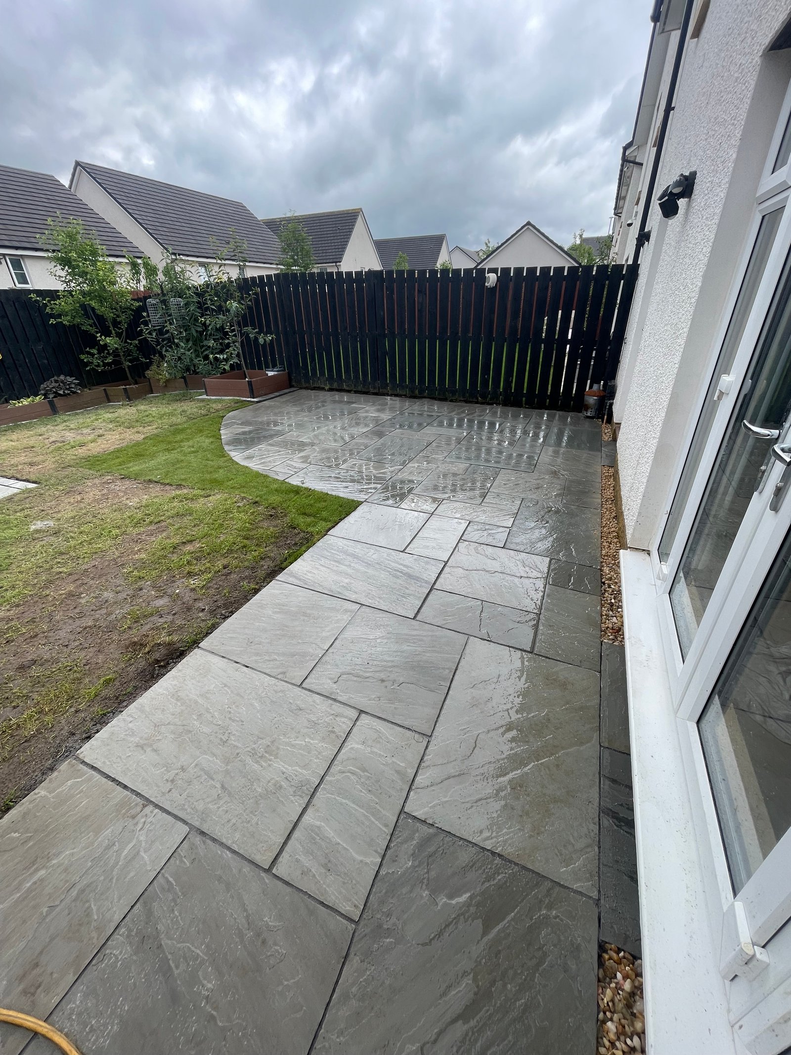 Grey Indian sandstone patio with new turf and borders in Glasgow
